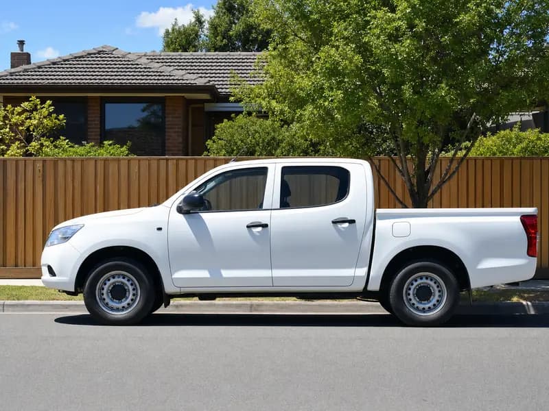 White ute parked beside a new timber fence on a suburban street